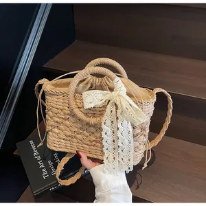 Details der Strohtasche mit Spitzenschleife, Kordelzugfutter und rundem Griff