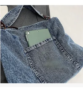 Macro shot of vintage denim tote bag featuring front pocket and large storage capacity