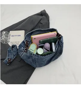 Top view of spacious interior of blue denim tote bag filled with daily essentials