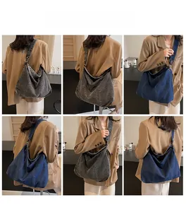Detail view of large denim shoulder bag with contrast stitching in blue and grey colors