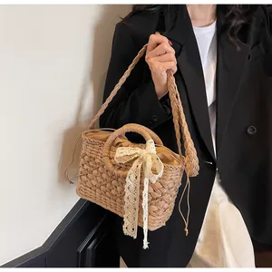 Detail der Stroh-Handtasche mit Spitzen-Schleife und praktischem Kordelzug-Verschluss