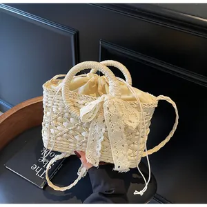 Detail der handgewebten Strohtasche mit zarter Spitzenschleife und Kordelzug-Innentasche