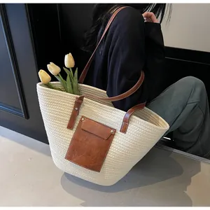 Détail d'un sac cabas tissé en coton avec poche en cuir et bandoulières marron