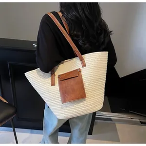Vue arrière d'un grand sac cabas tissé avec anses marron porté à l'épaule par un mannequin