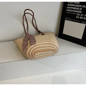 Détail d'un sac cabas en paille tressée avec anses en cuir et foulard en soie élégant