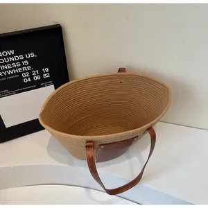 Détail du cabas en coton tressé avec poche en cuir et anses marron robustes