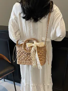 Böhmische Strohschultertasche mit weißer Spitzenschleife und Kordelzugfutter für Strandurlaub