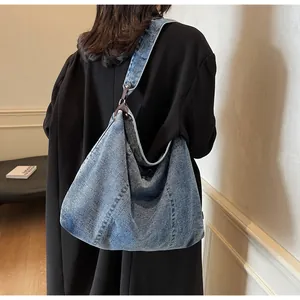 Detailed close-up of blue denim Hobo bag with heavy wash texture and metal ring buckle
