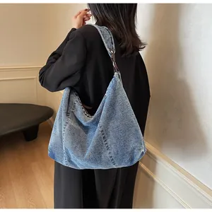 Detailed view of vintage denim tote bag with brown leather strap and metal ring