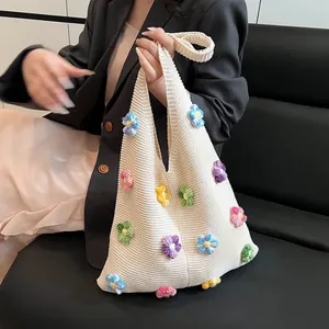 Texture tricotée détaillée du sac beige avec motifs de fleurs au crochet en 3D colorées