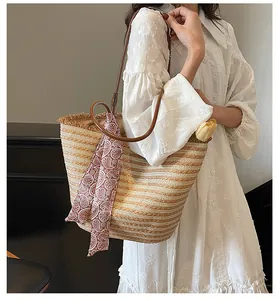 Détail du grand sac cabas en paille avec anses en cuir marron et foulard décoratif