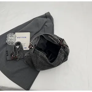 Detail of dark grey vintage denim tote with leather trim and removable shoulder strap