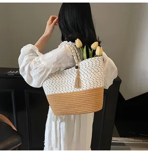Detail of bicolor woven beach bag with wooden beads and tassels in a lifestyle setting