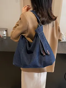 Vintage dark blue denim hobo bag with white stitching and leather knot strap detail
