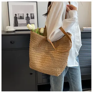 Vue détaillée d'un sac cabas en paille tissée à la main avec anses en cuir et tulipes