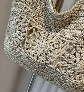 Close-up of the delicate woven craft and hollow floral patterns on a beige beach tote bag