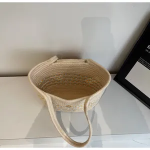 Detailed macro view of striped woven cotton rope tote bag in cream, blue and yellow colors
