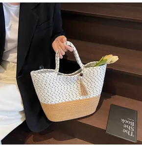 Detail of woven cotton tote bag featuring floral pattern, tassel charm, and fresh tulips