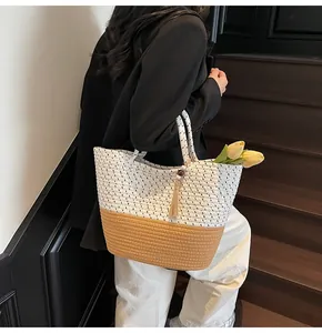 Detail of hand-woven cotton rope tote bag with bicolor stitching and tassel pendant
