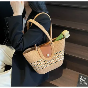 Detail of striped woven shoulder bag with brown leather flap and pearl button closure