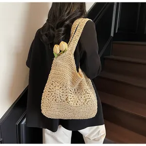 Detail of beige crochet tote bag featuring intricate hollow floral patterns for summer beach style