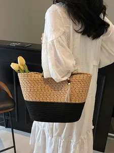 Women's woven tote bag with contrast design and tassel detail for summer beach vacations