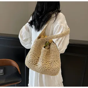 Close-up of woven hollow sunflower pattern on beige handmade straw shoulder bag