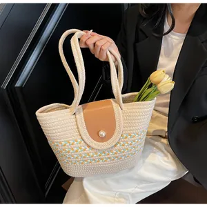 Detail of woven tote bag with a brown leather flap and large pearl button closure