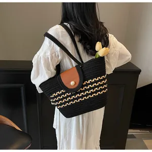 Detail of woven beach tote featuring stripe patterns and a large pearl button closure