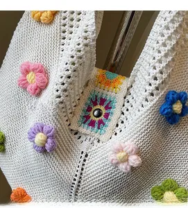 Dettaglio borsa a uncinetto bianca con fiori 3D colorati e motivo arcobaleno