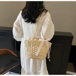 Détail du sac cabas en paille tissée avec nœud en dentelle blanche et doublure