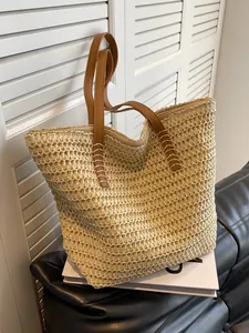 Grand sac fourre-tout beige en paille tressée avec anses en cuir marron pour la plage