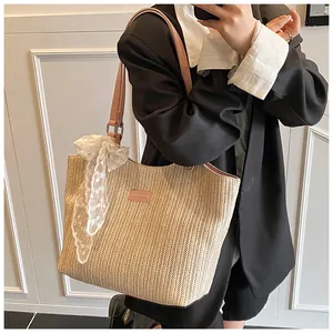 Detail of hand-woven beige tote with elegant white lace bow and light pink leather straps
