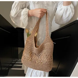Detail of hollow floral crochet pattern on a brown woven beach shoulder bag