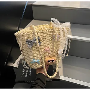 Détail d'un sac à main en paille avec nœud, dentelle et peluche pour la plage d'été