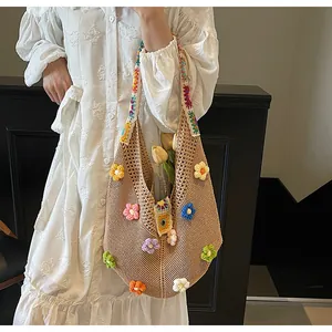 Dettaglio borsa in maglia boho con fiori all'uncinetto 3D e tracolla arcobaleno