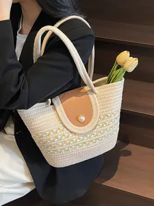 Striped woven handbag with pearl buckle and leather flap shown on a model