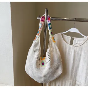 Dettaglio della borsa tote tessuta a mano con ricami floreali e texture all'uncinetto