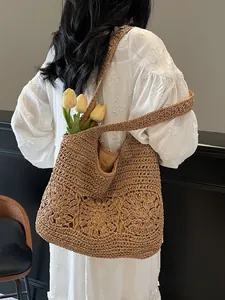 Handwoven straw shoulder bag with floral hollow design for beach vacations