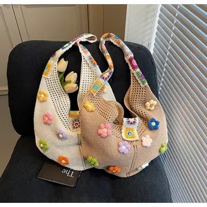 Dettaglio borsa in maglia con fiori 3D colorati e tracolla all'uncinetto boho