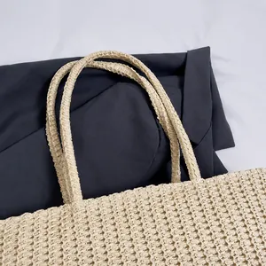 Detailansicht der gewebten Strohtasche mit robusten, verstärkten Doppelgriffen im Makro