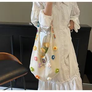 Dettaglio borsa hobo bianca all'uncinetto con fiori 3D colorati e trama a rete