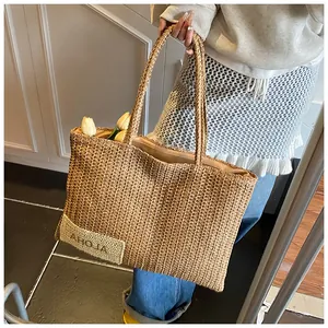 Dettaglio della borsa tote in paglia con toppa Aloha e tulipani decorativi interni