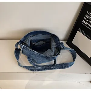 Detailed interior of a denim tote bag showing the zipper pocket and frayed edges