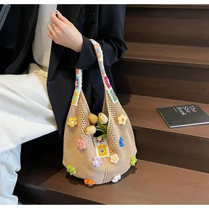Dettaglio ravvicinato di una borsa a tracolla in crochet fatta a mano con fiori 3D colorati