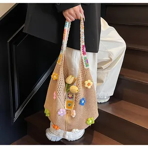 Dettaglio borsa in maglia beige con fiori 3D e trama all'uncinetto traforata