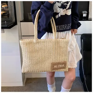 Dettaglio della borsa tote in paglia intrecciata con ricamo ALOHA per spiaggia estiva