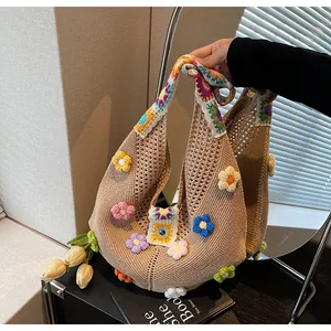 Dettaglio borsa in maglia con applicazioni floreali 3D e tracolla colorata bohémien