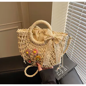 Detail of hollow woven straw bag featuring handmade floral charms and a lace bow