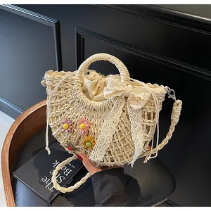 Detail of hollow woven straw bag with floral accents and cream lace bow decoration